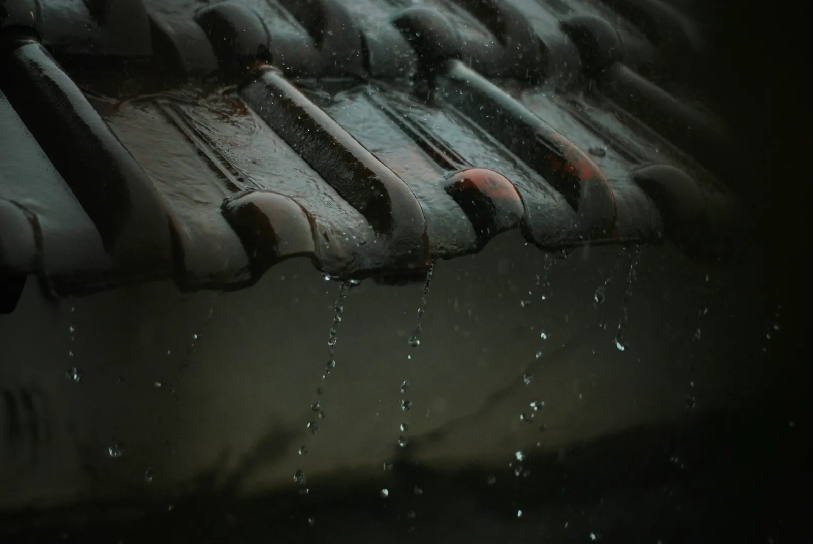 Pluie ruisselant sur des tuiles, photo d'illustration