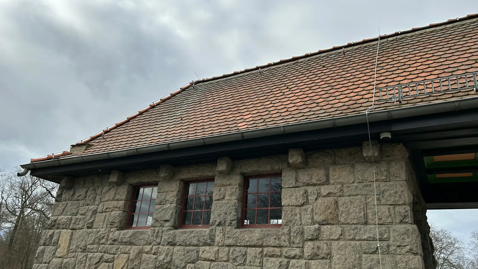 Maison en pierre et sa toiture en tuiles rouges