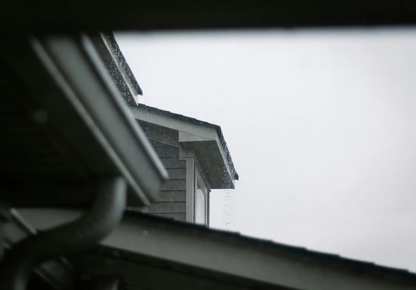 Toit et gouttières sous un ciel gris